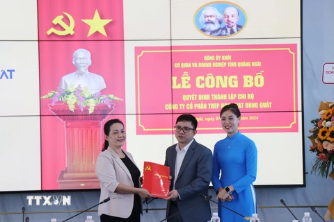 Bà Đinh Thị Hồng Minh (trái), Phó Bí thư Tỉnh ủy Quảng Ngãi trao Quyết định Bí thư Chi bộ Công ty Cổ phần Thép Hòa Phát Dung Quất cho ông Lưu Thanh Tùng. (Ảnh: Phạm Cường/TTXVN)