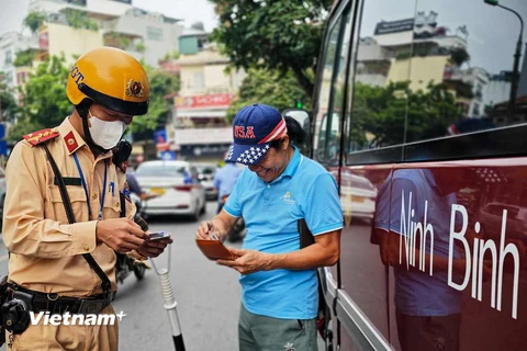 Cảnh sát giao thông tuần tra, xử lý xe khách, xe hợp đồng vi phạm trong khu vực phố cổ. (Ảnh Mạnh Khánh/Vietnam+)