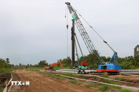 Công nhân làm việc tại gói thầu số 9 (huyện Mỹ Tú) thuộc dự án thành phần 4 thuộc Dự án Đầu tư xây dựng đường bộ cao tốc Châu Đốc-Cần Thơ-Sóc Trăng giai đoạn 1. (Ảnh: Tuấn Phi/TTXVN)