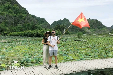 Du khách nước ngoài hòa cùng không khí kỷ niệm Cách mạng Tháng Tám và Quốc khánh 2/9 ở Khu du lịch Hang Múa, huyện Hoa Lư, tỉnh Ninh Bình. (Ảnh: Thùy Dung/TTXVN)