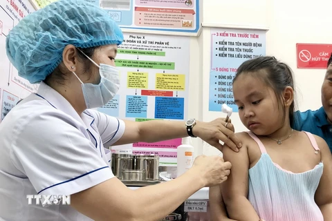 Nhân viên trạm Y tế phường An Lạc, quận Bình Tân tiêm vaccine phòng sởi cho trẻ. (Ảnh: Đinh Hằng/TTXVN)