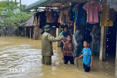 Vận động, hỗ trợ người dân ở những vùng ngập lụt di dời đến nơi an toàn. (Ảnh: TTXVN phát)