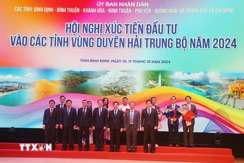 Lãnh đạo Ủy ban Nhân dân tỉnh Bình Định trao tặng quyết định chủ trương, giấy chứng nhận đầu tư cho các doanh nghiệp. (Ảnh: Sỹ Thắng/TTXVN)