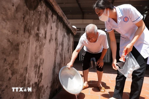 Hướng dẫn người dân xử lý nước thừa - môi trường để muỗi phát triển. (Ảnh: Minh Quyết/TTXVN)