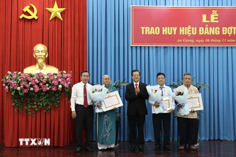 Lãnh đạo Tỉnh ủy An Giang trao tặng Huy hiệu 55 năm tuổi Đảng cho các đảng viên cao niên tuổi Đảng. (Ảnh: Thanh Sang/TTXVN)