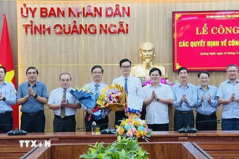 Lãnh đạo Ủy ban Nhân dân tỉnh Quảng Ngãi trao quyết định và tặng hoa chúc mừng Trưởng ban, Phó Trưởng Ban quản lý Khu kinh tế Dung Quất. (Ảnh: TTXVN)