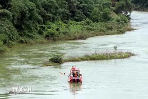 Các lực lượng tham gia tìm kiếm người mất tích ở dưới sông. (Ảnh: Đỗ Trưởng/TTXVN)