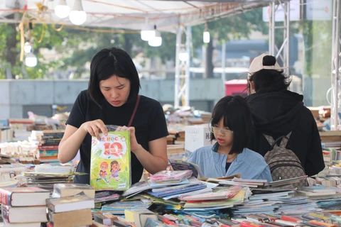 Hội sách là cơ hội để phụ huynh tìm những đầu sách hay và xây dựng cho con thói quen đọc sách. (Ảnh: Việt Anh/Vietnam+)