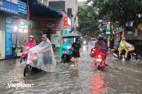 [Photo] Người dân Thủ đô bì bõm lội mưa trong giờ tan tầm