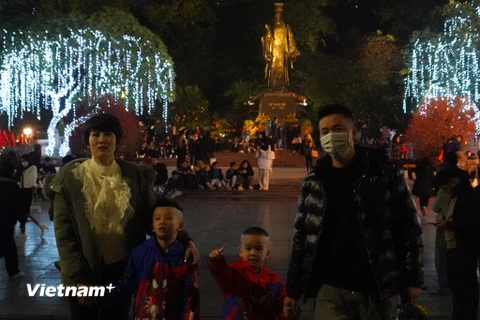 Đêm 30 Tết Âm lịch, nhiều gia đình tại Thủ đô Hà Nội đã ra đường từ sớm để chuẩn bị chờ đón khoảnh khắc chuyển giao giữa năm cũ và năm mới. (Ảnh: Việt Anh/Vietnam+)