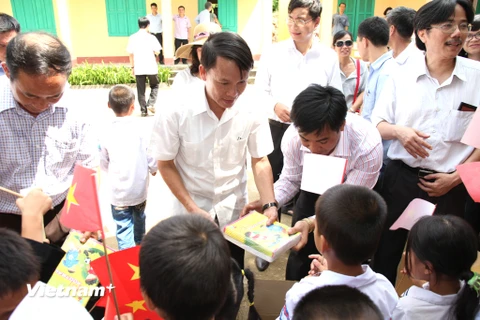 Ông Nguyễn Đức Lợi trao quà cho các em học sinh. (Doãn Đức/Vietnam+)