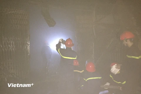 Lực lượng cứu hỏa nỗ lực dập lửa tại chợ Xốm Hà Đông đêm 24/10 (Ảnh: PV/Vietnam+) 
