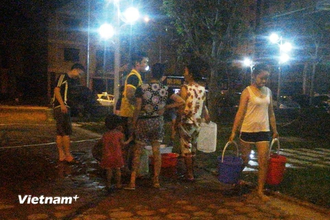 Cư dân phải xách từng xô nước lên các tầng cao trong đêm 16/5 (Ảnh: Hải Minh/Vietnam+) 