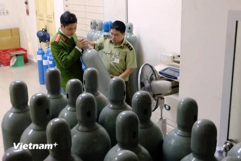 Cảnh sát kiểm tra các bình chứa khí cười tối 23/3 (Ảnh: PV/Vietnam+) 