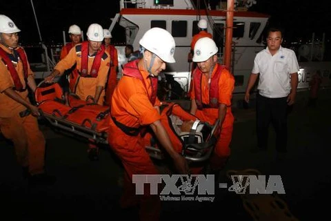 Chuyển nạn nhân từ tàu SAR 412 lên bờ để đưa vào bệnh viện tiếp tục điều trị. (Ảnh: Trần Lê Lâm/TTXVN) 
