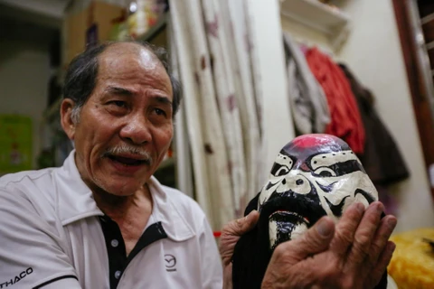 Nghệ sỹ Kim Kê và bộ sưu tập mặt nạ tuồng cổ của mình (Ảnh: Minh Sơn/Vietnam+)
