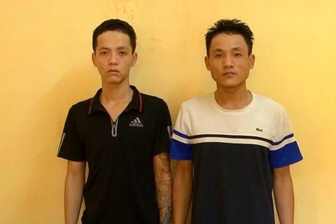 Hai đối tượng Trần Văn Giỏi (bên trái) và Trần Đức Lương tại cơ quan công an (Ảnh: PV/Vietnam+) 