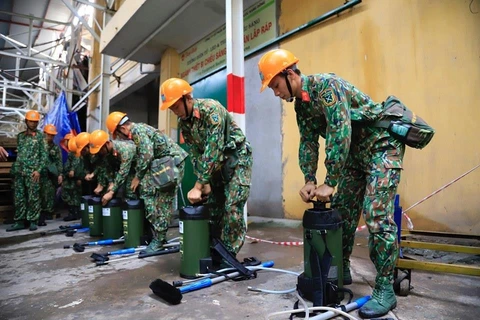 Bộ đội của Bộ Tư lệnh hoá học chuẩn bị tẩy độc bên trong kho bị cháy. (Ảnh: PV/Vietnam+) 