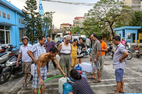 Người dân lấy nước sạch sau sự cố sông Đà. (Ảnh: Minh Sơn/Vietnam+) 