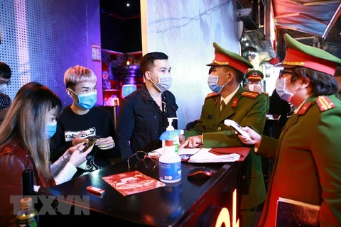 Lực lượng Công an quận Hoàn Kiếm kiểm tra thiết bị đo thân nhiệt tại vũ trường The Bunker, nơi tập trung đông người tại phố Mã Mây, quận Hoàn Kiếm. (Ảnh: Doãn Tấn/TTXVN) 