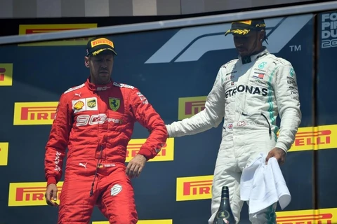 Vettel (áo đỏ) tỏ ra khó chịu khi bước lên bục nhận giải. (Ảnh: CTV)