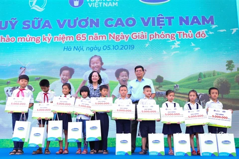 Bà Trương Thị Mai - Ủy viên Bộ Chính trị, Bí thư Trung ương Đảng, Trưởng ban Dân vận Trung ương cùng đại biểu khách mời trao học bổng và sữa của Quỹ Sữa Vươn Cao Việt Nam cho các em học sinh khó khăn có thành tích học tập tốt của trường Tiểu học Tiên Dược