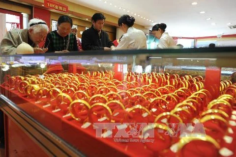 Khách hàng chọn mua đồ trang sức bằng vàng tại một cửa hàng tỉnh Giang Tô (Trung Quốc). (Ảnh: AFP/TTXVN)