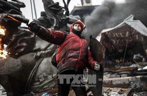 Người biểu tình ném bom xăng vào cảnh sát tại Kiev ngày 20/2. (Ảnh: AFP/TTXVN)