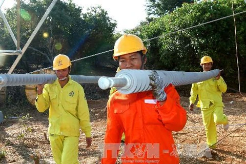 Công nhân Công ty cổ phần Sông Đà 11 lắp đặt thiết bị cách điện và kéo dây đoạn qua huyện Bù Đăng, Bình Phước. (Ảnh: Ngọc Hà/TTXVN)