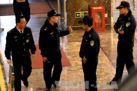 Cảnh sát Trung Quốc gác tại cửa Khách sạn Lido, nơi thân nhân các hành khách trên máy bay mất tích lưu trú trong khi chờ tin tức vụ việc, ở Bắc Kinh (Trung Quốc) ngày 17/3. (Ảnh: AFP/TTXVN)
