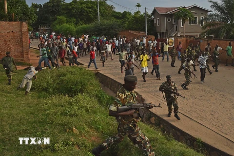 Binh sỹ Burundi cố gắng duy trì an ninh trong khi biểu tình diễn ra tại Musaga, ngoại ô thủ đô Bujumbura ngày 20/5. (Nguồn: AFP/TTXVN)