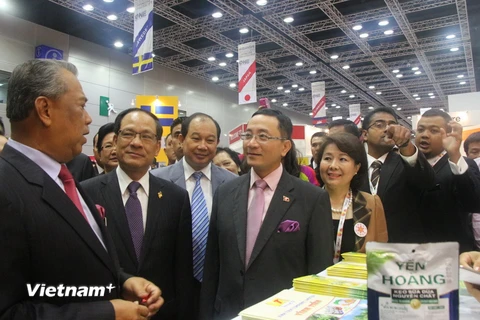 Phó Thủ tướng Malaysia Muhyiddin Yassin (đi đầu) và Tổng Thư ký ASEAN Lê Lương Minh (thứ hai) thăm gian hàng của Việt Nam. (Ảnh: Kim Dung-Chí Giáp/Vietnam+)