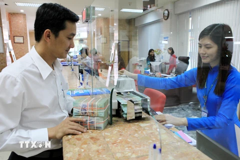 Làm thủ tục vay vốn tại Ngân hàng VietinBank chi nhánh Thành phố Hồ Chí Minh. (Ảnh: Trần Việt/TTXVN) 