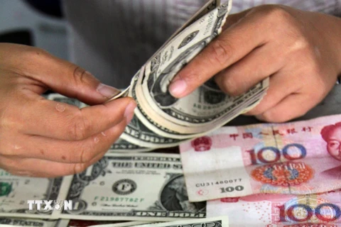 Kiểm đồng USD và đồng nhân dân tệ tại ngân hàng ở Sơn Đông. (Nguồn: THX/TTXVN)