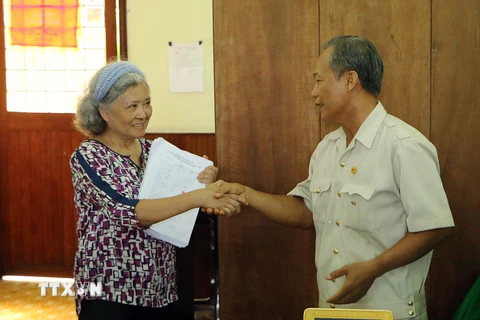 Ông Nguyễn Đại Lượng, Chủ tịch Hội nạn nhân chất độc da cam Sóc Trăng trao cho bà Trần Tố Nga hơn 17.000 chữ ký ủng hộ vụ kiện đòi công lý. (Ảnh: Trung Hiếu/TTXVN)