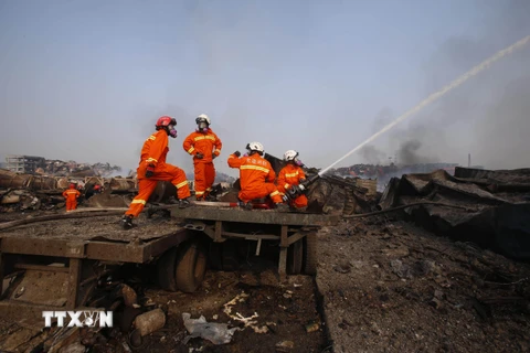 Nhân viên cứu hỏa tại hiện trường vụ nổ ở Thiên Tân. (Nguồn: THX/TTXVN)