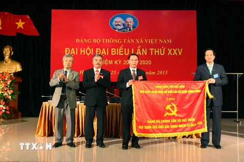 Ông Đào Ngọc Dung trao cờ thi đua cho Tổng Giám đốc Thông tấn xã Việt Nam Nguyễn Đức Lợi. (Ảnh: Quý Trung/TTXVN)