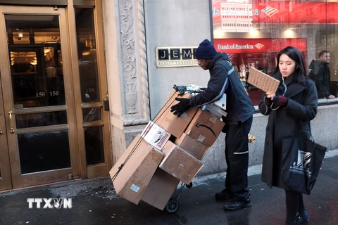 Người làm dịch vụ giao hàng tại thành phố New York. (Nguồn: AFP/TTXVN)