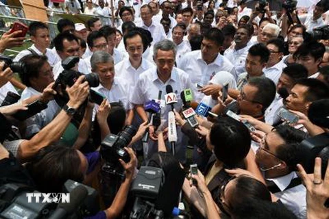 Thủ tướng Singapore Lý Hiển Long (giữa) trả lời báo giới sau khi nộp đơn đăng ký tranh cử ngày 1/9. (Nguồn: AFP/TTXVN)