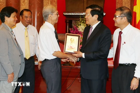 Chủ tịch nước Trương Tấn Sang tặng quà lưu niệm cho cán bộ ngành Tòa án nhân dân qua các thời kỳ. (Ảnh: Nguyễn Khang/TTXVN)