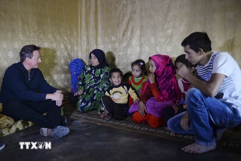 :Thủ tướng Anh David Cameron (trái) thăm khu định cư cho người tị nạn ở thung lũng Bekaa, Liban ngày 14/9. (Nguồn: AFP/TTXVN)