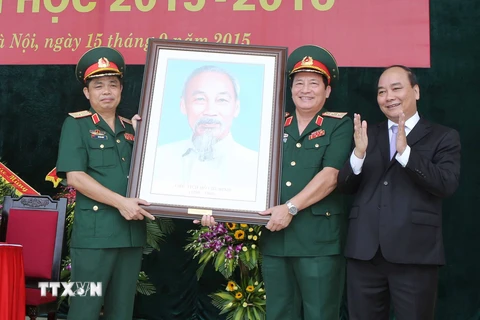 Phó Thủ tướng Nguyễn Xuân Phúc tặng quà lưu niệm cho Học viện Hậu cần. (Ảnh: Phương Hoa/TTXVN)