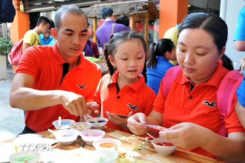Các gia đình trẻ tham gia trò chơi vẽ tranh cát tại Ngày Gia đình Việt Nam 2015 tại Thành phố Hồ Chí Minh. (Ảnh: An Hiếu/TTXVN)