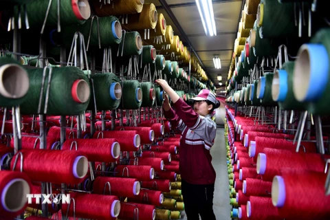 Công nhân làm việc tại một nhà máy dệt thảm ở tỉnh Sơn Đông, miền Đông Trung Quốc. (Nguồn: THX/TTXVN)