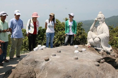Du khách tham quan đỉnh bàn cờ tiên -nơi bắt nguồn về truyền thuyết "Tiên sa" trong tour du lịch khám phá. (Ảnh: Văn Sơn/TTXVN)