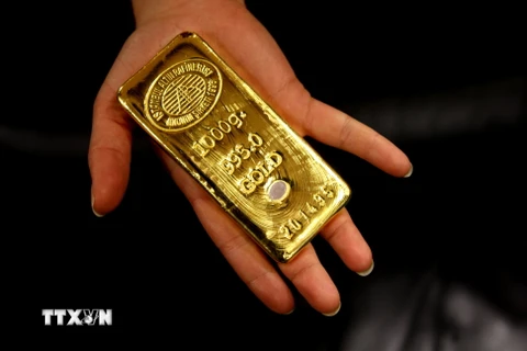 Công nhân giới thiệu một thoi vàng để bán, tại Nhà máy Tinh chế Vàng Istanbul, Thổ Nhĩ Kỳ. (Nguồn: AFP/TTXVN)