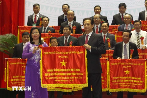 Thủ tướng Nguyễn Tấn Dũng tặng cờ thi đua của Chính phủ cho các huyện đã có thành tích xuất sắc trong phong trào xây dựng Nông thôn mới. (Ảnh: Vũ Sinh/TTXVN)