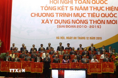 Thủ tướng Chính phủ Nguyễn Tấn Dũng tặng cờ thi đua của Chính phủ cho các huyện đã có thành tích xuất sắc trong phong trào xây dựng Nông thôn mới. (Ảnh: Vũ Sinh/TTXVN)