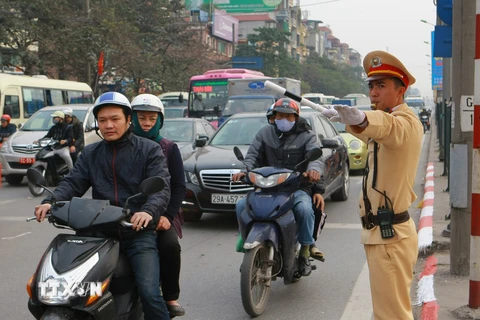 Chiến sỹ cảnh sát giao thông Hà Nội làm nhiệm vụ phân luồng giao thông trong giờ cao điểm trên trục đường Giải Phóng. (Ảnh: Doãn Tấn/TTXVN)