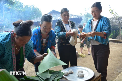 Phụ nữ dân tộc Mông tại xã Pá Lông, huyện Thuận Châu, Sơn La gói bánh dày. (Ảnh: Công Luật/TTXVN)